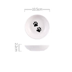 White ceramic bowl with black paw prints and measurements on a white background
