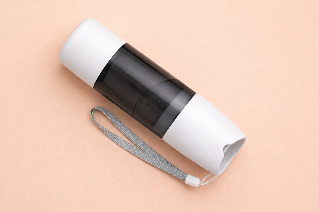 Clear water bottle with white cap and gray strap on a beige background
